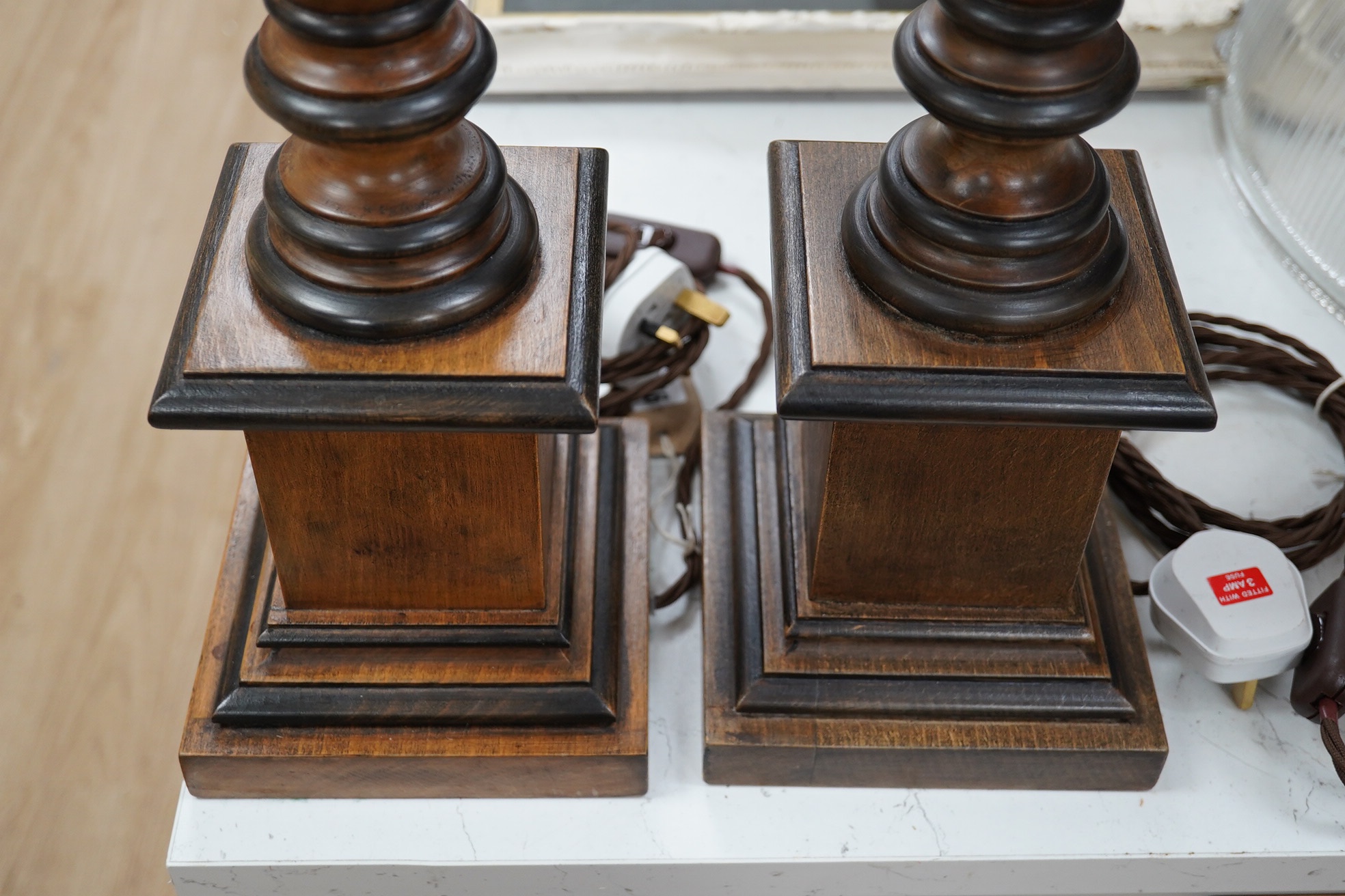 A pair of vintage English carved wood table lamps, wired, 54cm high to top of bulb holder, 55cm high. Condition - good